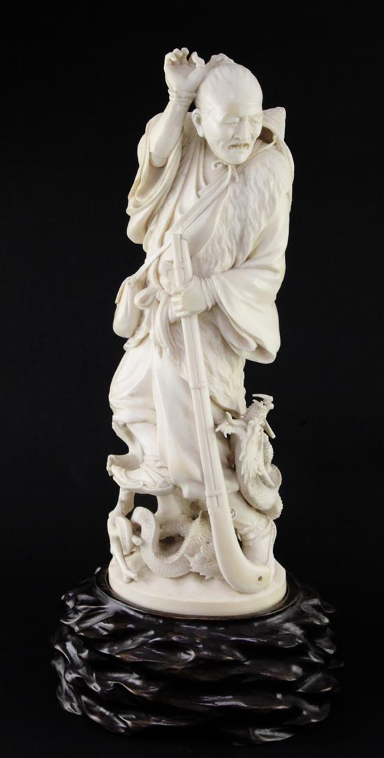 A good Japanese Tokyo School ivory okimono of a hunter and a dragon, signed Nobuaki(?), Meiji period, 34cm, wood stand